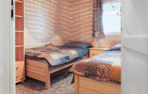 a bedroom with two beds in a wooden wall at z widokiem na zalew in Sułomino