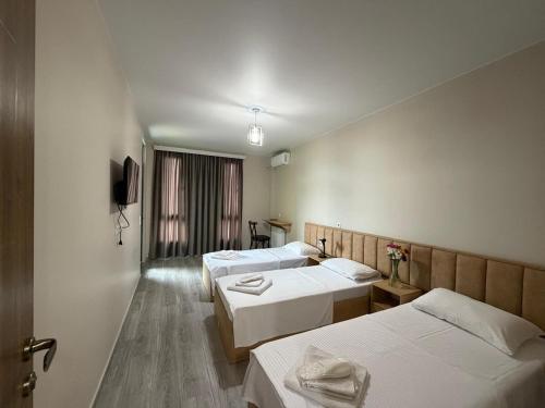 a hotel room with three beds and a tv at DeltaHotel in Ureki