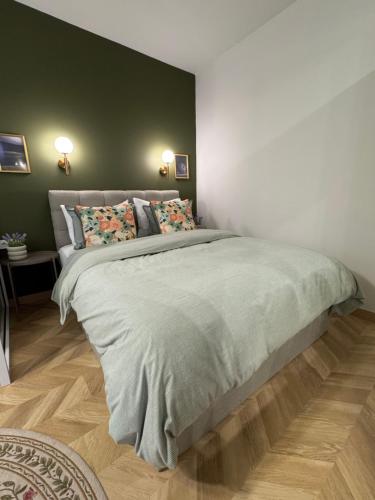 a bedroom with a large bed with a green wall at Atelie Home Experience 2 in Serres