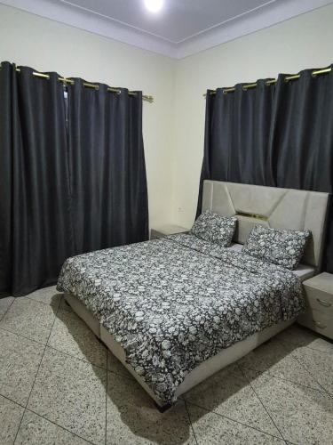 a bedroom with a bed with black curtains at Appartement familial villa 110 m2 jardin et piscine in Meknès