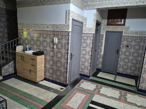 a bathroom with a sink and tiles on the walls at Appartement familial villa 110 m2 jardin et piscine in Meknès