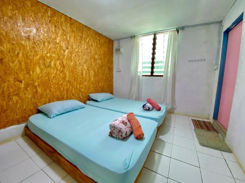 a bedroom with two beds with stuffed animals on it at DA Family Mini Garden in Ranau