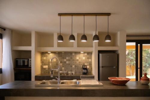 a kitchen with a sink and two pendant lights at Sama Lodge in Saly Portudal