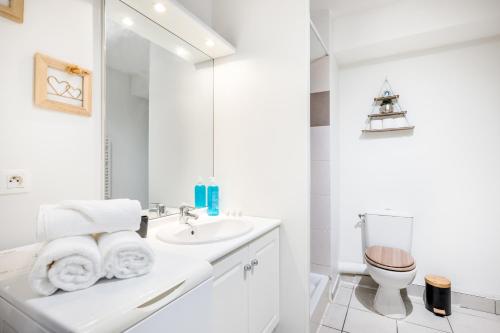 a white bathroom with a sink and a toilet at BnGo I Le Cosy des Canuts I Parking, 2p, proche hôpital in Caluire-et-Cuire