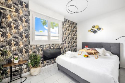 a bedroom with two beds and a window at BnGo I Le Cosy des Canuts I Parking, 2p, proche hôpital in Caluire-et-Cuire