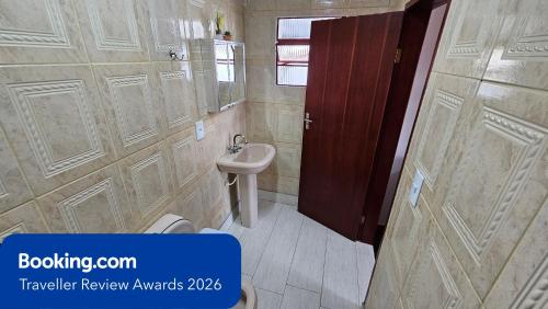 a bathroom with a white toilet and a sink at Casa dos Coelhos, 750m do centro, até 12 pessoas in Tiradentes