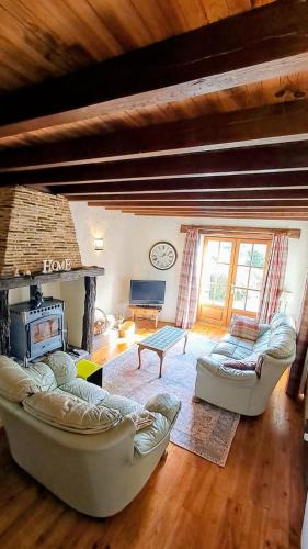 a living room with two couches and a fireplace at Maison Saint Romain in Saulgond