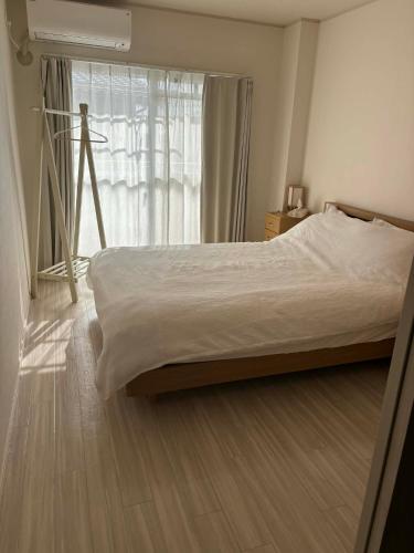 a bedroom with a bed and a large window at Shimaville Japan, El Corpo in Matsudo