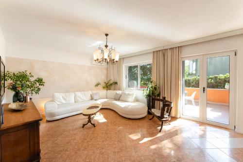 a living room with a white couch and a table at Apartmant with Pool 8 in Kaštela