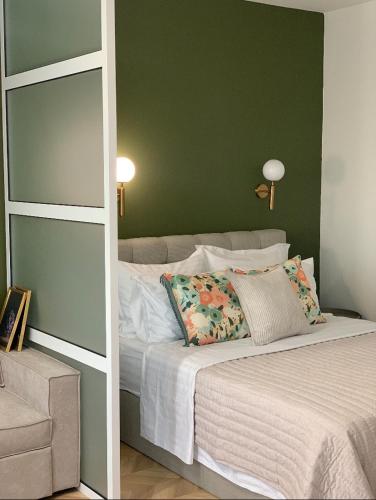 a bedroom with a bed with a green wall at Atelie Home Experience 2 in Serres