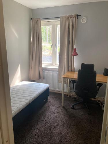 a bedroom with a bed and a desk and a window at Hus i Los in Los