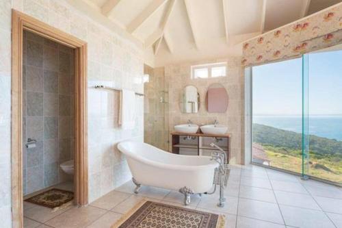 a large bathroom with a tub and two sinks at Rothman's Sea View in Pacaltsdorp