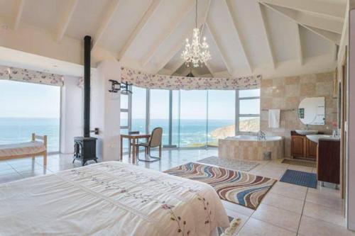 a bedroom with a large bed and a room with the ocean at Rothman's Sea View in Pacaltsdorp