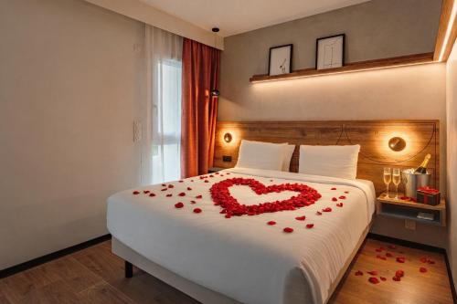 a bedroom with a bed with a heart made out of roses at KYRIAD DAX - Saint Paul lès Dax in Saint-Paul-lès-Dax