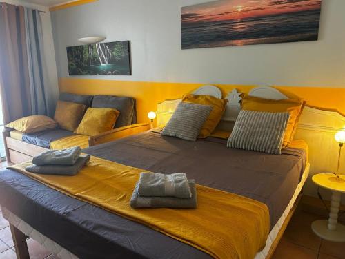 a bedroom with a large bed and a couch at Studio Saint Vincent 13 Non PMR in Sainte-Luce