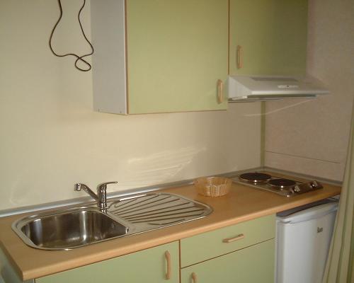 a small kitchen with a sink and a stove at Parque de Campismo Orbitur Valado in Nazaré
