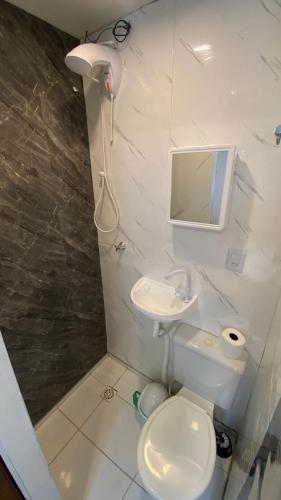 a bathroom with a toilet and a sink and a mirror at Solar do Braz Tiny House in Florianópolis