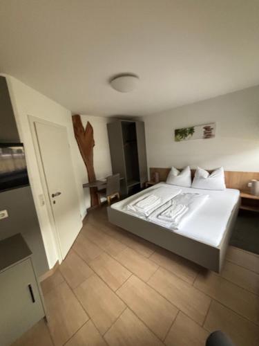 a bedroom with a large white bed in a room at Pension SUNNSEITN - Gastronomie - Café - Weinkeller in Haslach an der Mühl