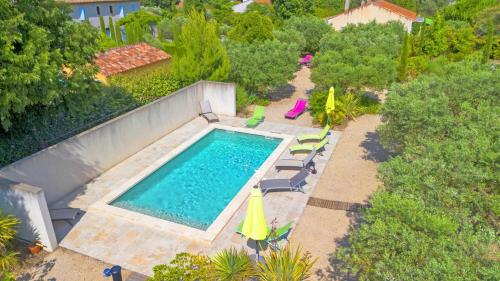 widok z góry na basen z krzesłami i parasolami w obiekcie Villa Le Cèdre w mieście Saint-Rémy-de-Provence