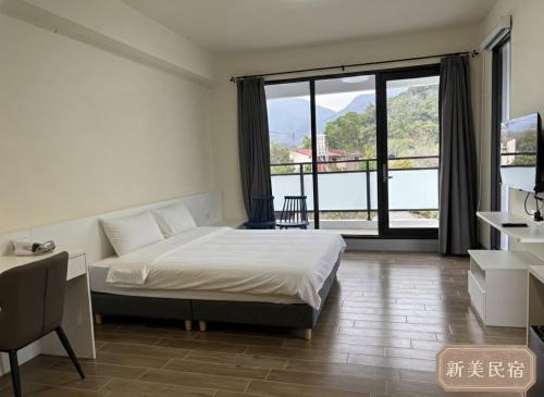 a bedroom with a bed and a large window at Shin Mei B&B in Puli