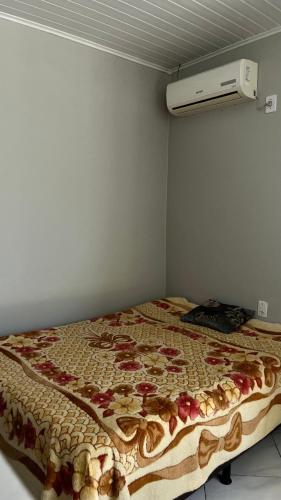a bedroom with a bed with a quilt on it at Pousada Azambuja in Cidreira