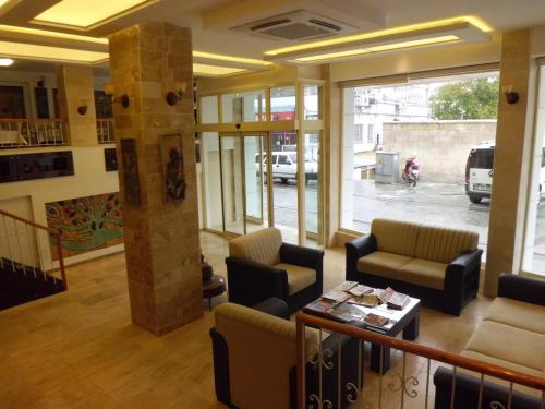 un vestíbulo con sillas y una mesa en un edificio en Utkubey Hotel, en Gaziantep