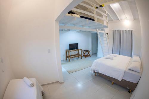 a bedroom with a white bed and a staircase at Hi Adventure in Florianópolis