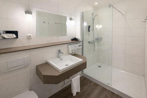 a bathroom with a sink and a shower at Romantik Hotel Schloss Reichenow in Reichenow