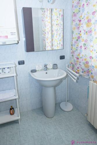 a white bathroom with a sink and a mirror at Casa da Luna in Parma