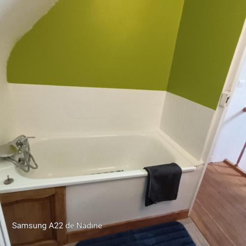 a bath tub with a sink and a black towel at Les Pommerets in Le Petit-Couronne