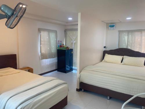 a bedroom with two beds and a window at Aiem-Wilai Guesthouse in Suratthani