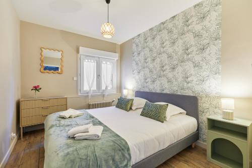 a bedroom with a bed and a wall at Jeanne d'Arc - Plage à pied - Central in Villerville