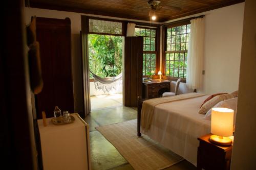 a bedroom with a bed and a sliding glass door at Pousada Santa Martha in Ubatuba