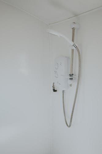 a shower in a bathroom with a white wall at Charnock Farm in Leyland