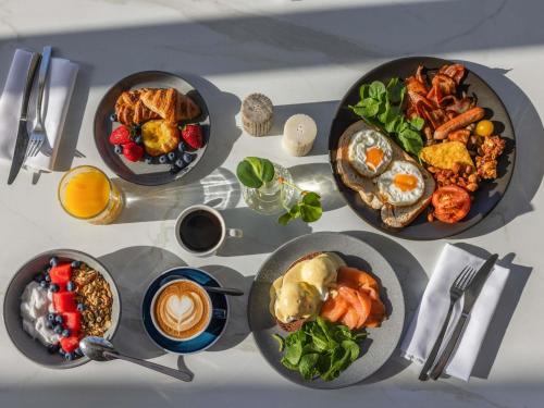a table with many plates of food on it at Peppers Blue on Blue in Nelly Bay