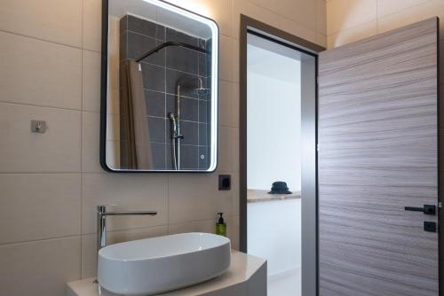 a bathroom with a sink and a mirror at Helios Blue Villas Kriopigi Kassandra in Kriopigi