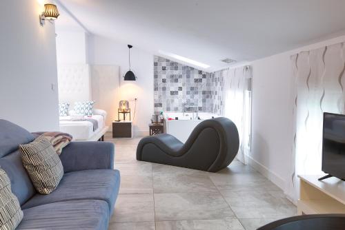 a living room with a blue couch and a tv at Apartamentos Cabañas in Carboneras de Guadazaón