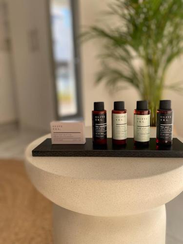 a table with four bottles of hair products on it at Cottage Boutique Apartments Athens in Athens
