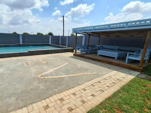 a swimming pool with a pavilion and a picnic table at Eden Villas Guesthouse in Kuruman