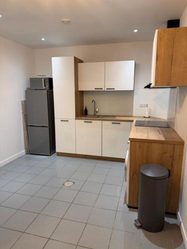 a kitchen with white cabinets and a black refrigerator at Le Petit Sancerrois in Sancerre