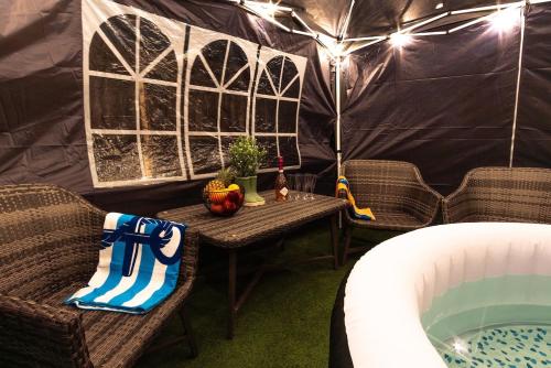 a tent with a table and chairs and a hot tub at 2BR House Hot Tube Airport A38 A50 Parking in Burton upon Trent