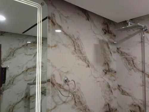 a marble shower with a glass door in a bathroom at Premium 3BHK with UPS, across Giga Mall, Pool Included in Islamabad