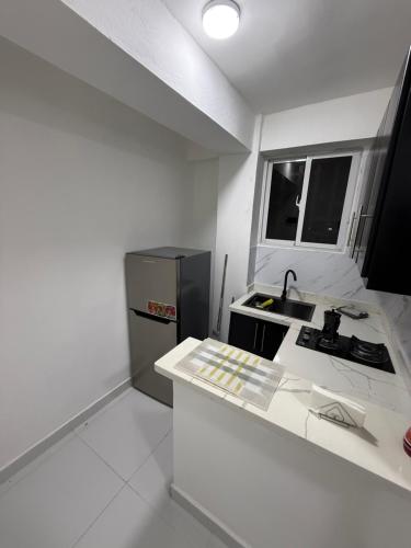 a white kitchen with a sink and a refrigerator at Moon Apartamento C2 in San Cristóbal