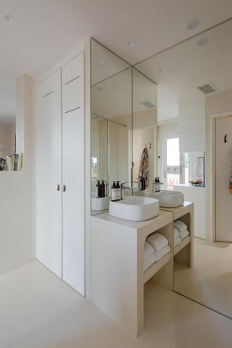 a white bathroom with two sinks and a mirror at MiHotel - La Maison Rose in Lyon