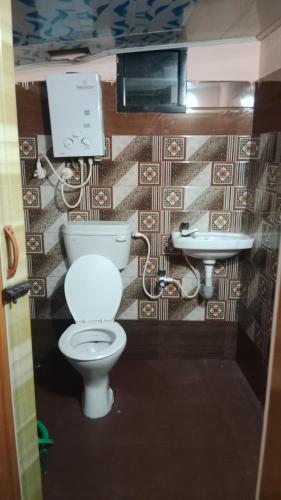 a bathroom with a toilet and a sink at Danny's Homestay Coorg in Madikeri
