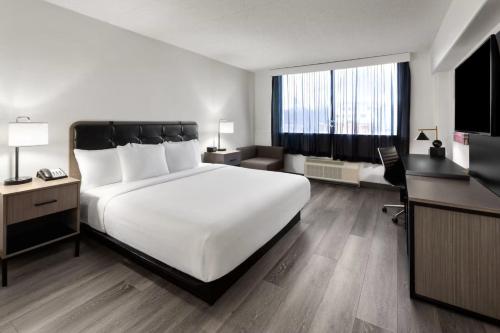 a bedroom with a large white bed and a living room at Holiday Inn Express & Suites Washington DC - NoMA by IHG in Washington, D.C.