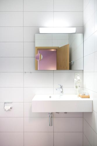 a white bathroom with a sink and a mirror at Hotel Wolfsjäger in Herbern