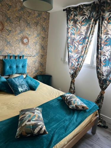 a bedroom with a bed with blue sheets and curtains at Chambre chaleureuse in Grosley-sur-Risle