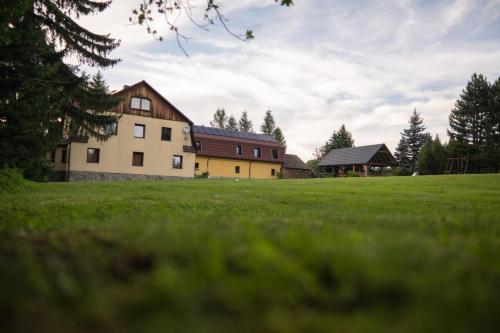 a house in a field with a grassy field at Góry Sowie Agroturystyka in Rzeczka