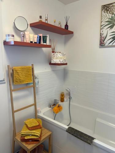 a bathroom with a bath tub and a sink at Chambre chaleureuse in Grosley-sur-Risle